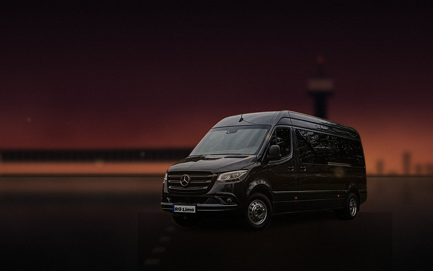 Black Mercedes-Benz Sprinter van waiting at an airport arrivals kerb in Los Angeles as the last light drops